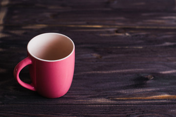 empty red mug on a dark wooden table