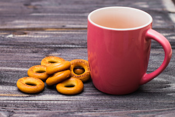 empty red mug and bagels on a dark wooden table