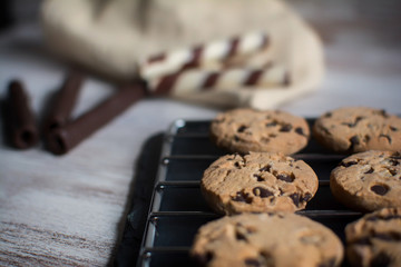 Cake shop. Freshly made chocolate chip cookies on a baking sheet. In the background chocolate waffles. Close up and depth of field