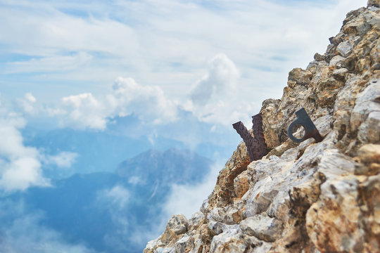 Remains of a steel rock anchor and an old climbing piton on via ferrata Eterna route, in Dolomites mountains, Italy.