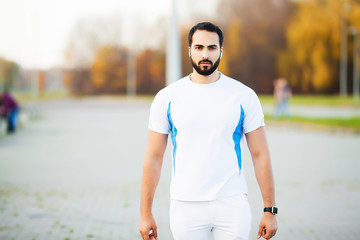 Fit muscular man running outside. Fitness and sport concept