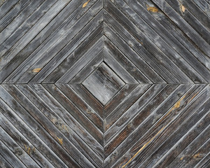 Close-up view of the old weathered wooden surface with planks laid in the form of a rhombus or...