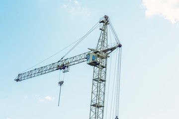 Building crane on blue sky background with clouds