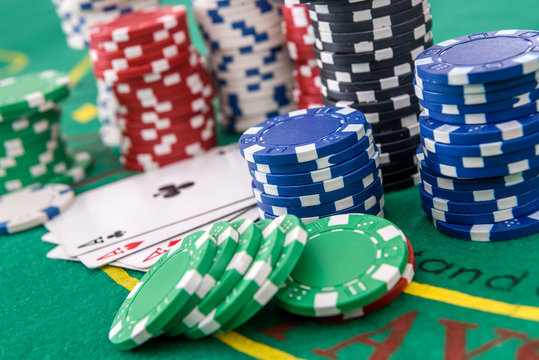 Gambling theme. Colorful casino chips on green poker table close up