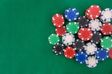 Colorful casino chips on green felt table close up. Gambling concept. Playing poker and other gambling games