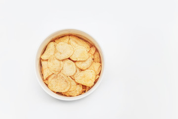 Crispy potato chips in bowl on white background, top view