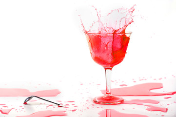 Red alcohol cocktail drink splash on white background .