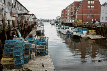 Commercial fishing wharf with stacks of lobster traps in the Old Port Harbor district of Portland,...