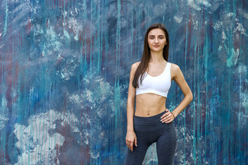 Fototapeta premium Portrait of slim and sportive woman on abstract background. Sport and health