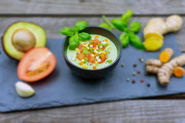 leckere Avocadocreme mit Ingwer, Tomate und Kurkuma und Basilikum mit unscharfem Hintergrund