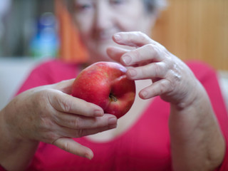 Portrait of mature woman smiling with red apple in hands
