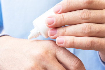 Man uses hand cream, women's hands, close up, toned