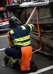 Rescue intervention man tries to secure a turned car to release the victim