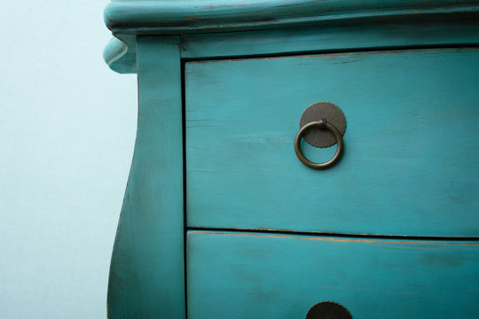 Old blue chest of drawers in the studio, side view, cropped image, close up