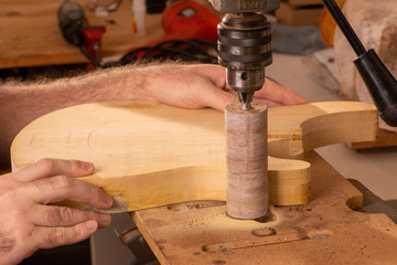 luthier sanding the body of a guitar