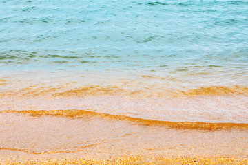The texture of sea water with a fragment of a small shell rock near the shore
