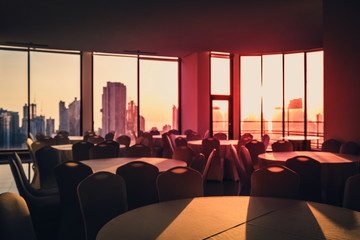 abstract blurry image of empty dining room with city  skyline and  sunset sky