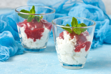 Glass cup  of rice pudding with berry sauce and  mint leaves