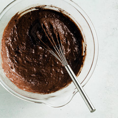 chocolate batter, ready to bake in a glass bowl with a whisk
