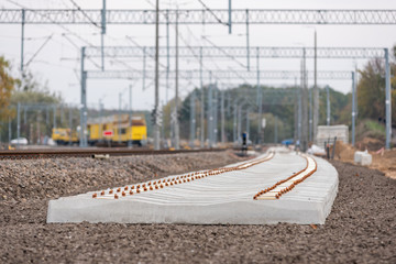Modernization of the railway line. New track, crushed stone, railway sleepers, poles, trusses and energy infrastructure. - Powered by Adobe