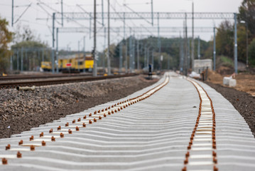 Fototapeta na wymiar Modernization of the railway line. New track, crushed stone, railway sleepers - close-up