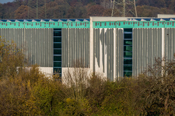Lackbeschichtung blättert ab an der Fassade eines Industriegebäudes