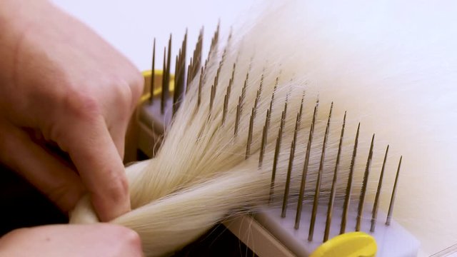 Wig Hair Combing. Wig production, female hands close-up.