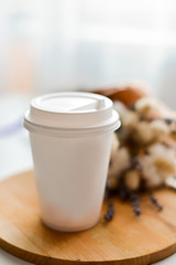 white cardboard cup on a background of dried flowers