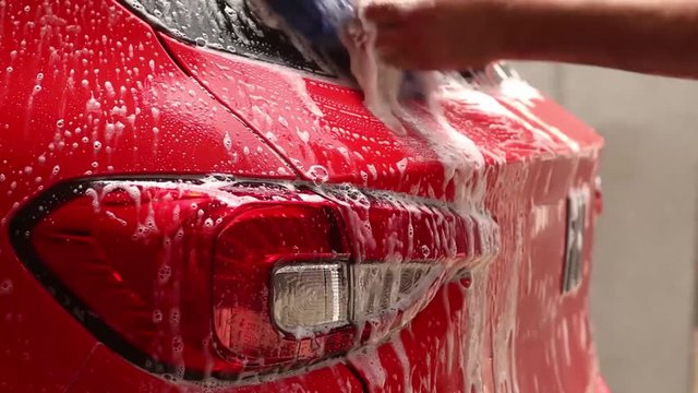 red car wash with pressure washer