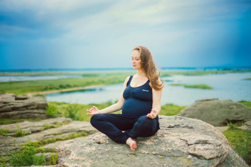 Fototapeta na wymiar pregnant woman doing yoga outside