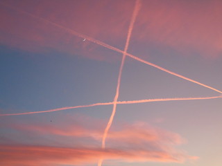 Genova, Italy - 01/25/2020: An amazing caption of the sunset in winter days over the city of Genova with beautiful red sky, some amazing clouds and small moonlight in the background.