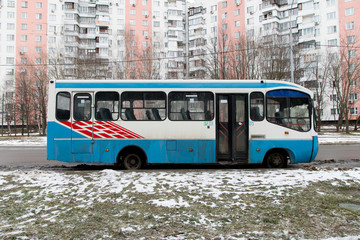 Blue and white bus stands on the side of the road