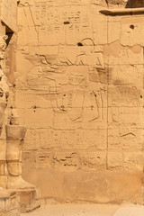 Karnak Temple, complex of Amun-Re. Embossed hieroglyphics on walls. Luxor Governorate, Egypt. Min  is an ancient Egyptian god.