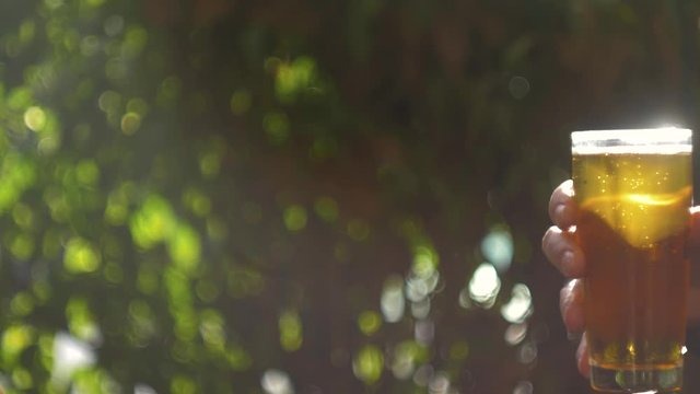 Celebration beer cheers concept - close up hands holding up glasses of beer of people group in outdoor party during their victory competition or successful task meeting vacation