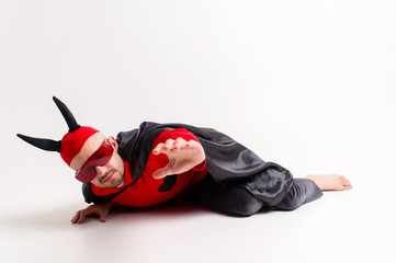 Conceptual portrait of defeated and helpless devil man in black red vampire costume asking for help...