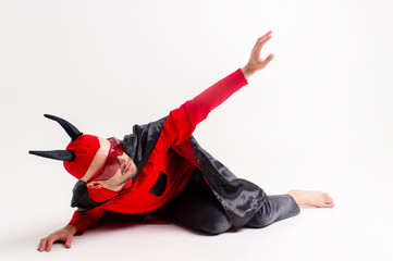 Conceptual portrait of defeated and helpless devil man in black red vampire costume asking for help...
