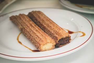 Churros stuffed with chocolate and cream in Madrid, typical spanish dessert