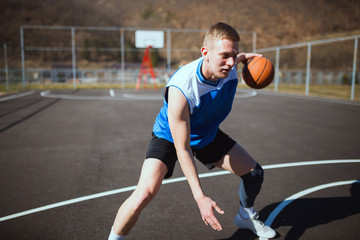 Basketball player doing dribbling at street court