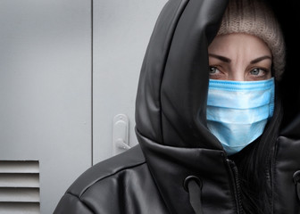Portrait of an unhappy woman in a mask to fight the virus or pollution. Global danger. Outbreak of...