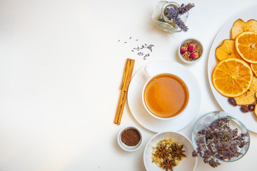 Fototapeta na wymiar herbal tea in white cup with ingredients on white background