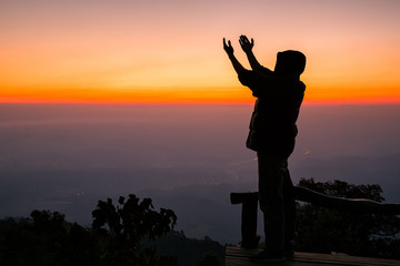 Silhouette of christian man hand praying