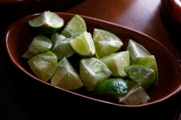 green lemons cut in bowl