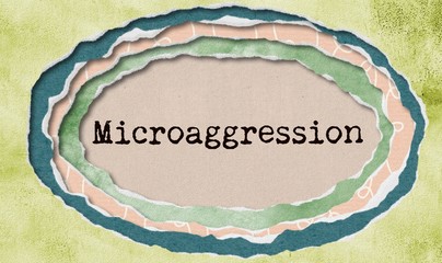 Microaggression - typewritten word in ragged paper hole background - concept tattered illustration