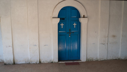 Naklejka premium Blue door to the Church, a door with Christian crosses