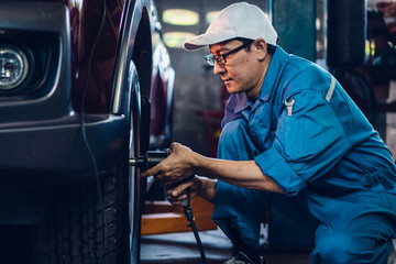car mechanic checking and repair customer car at garage and maitenance station