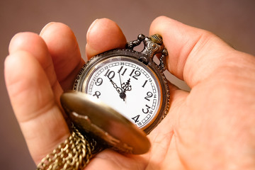 a pocket watch in the hands of a man