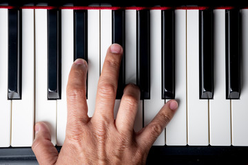 right hand playing a C Minor chord on the piano