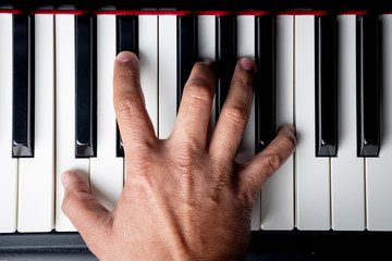 right hand playing a C Minor seventh chord on the piano