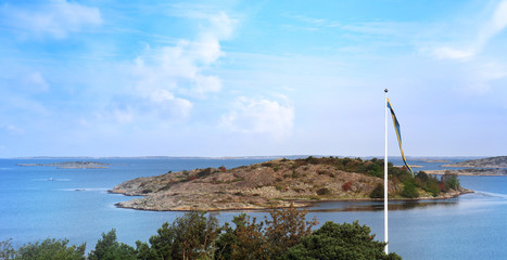 Seascape by the West Coast of Sweden. Swedish flag in the landscape during Summer.