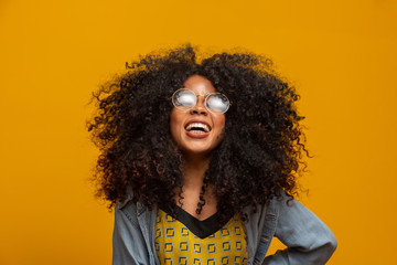 Beauty portrait of african american with glasses and afro hairstyle on a yellow background....